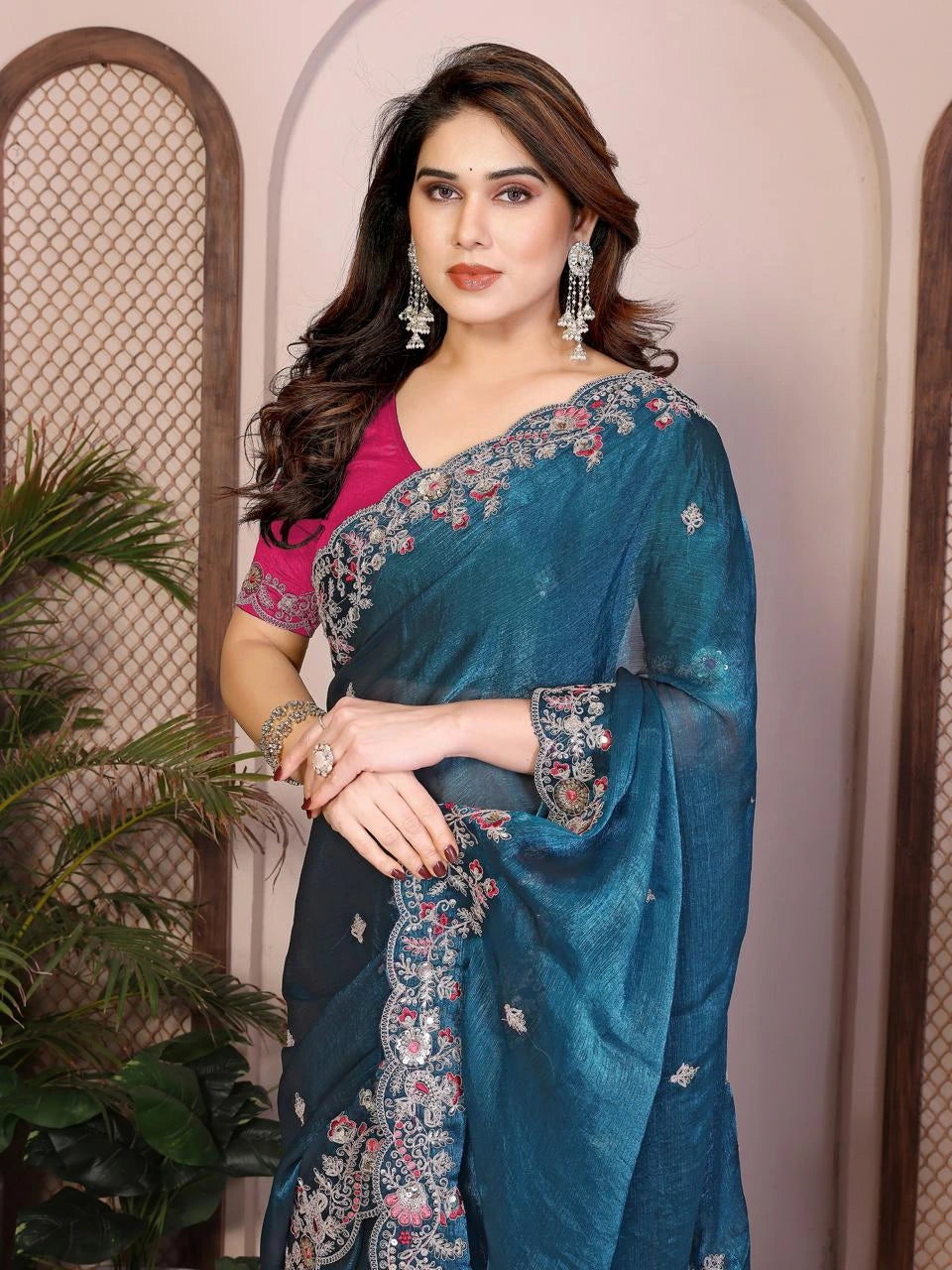 Woman wearing a blue saree with floral patterns indoors